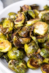 A close up shot of crispy roasted brussel sprouts to show the super crunchy little leaves lightly coated in oil.