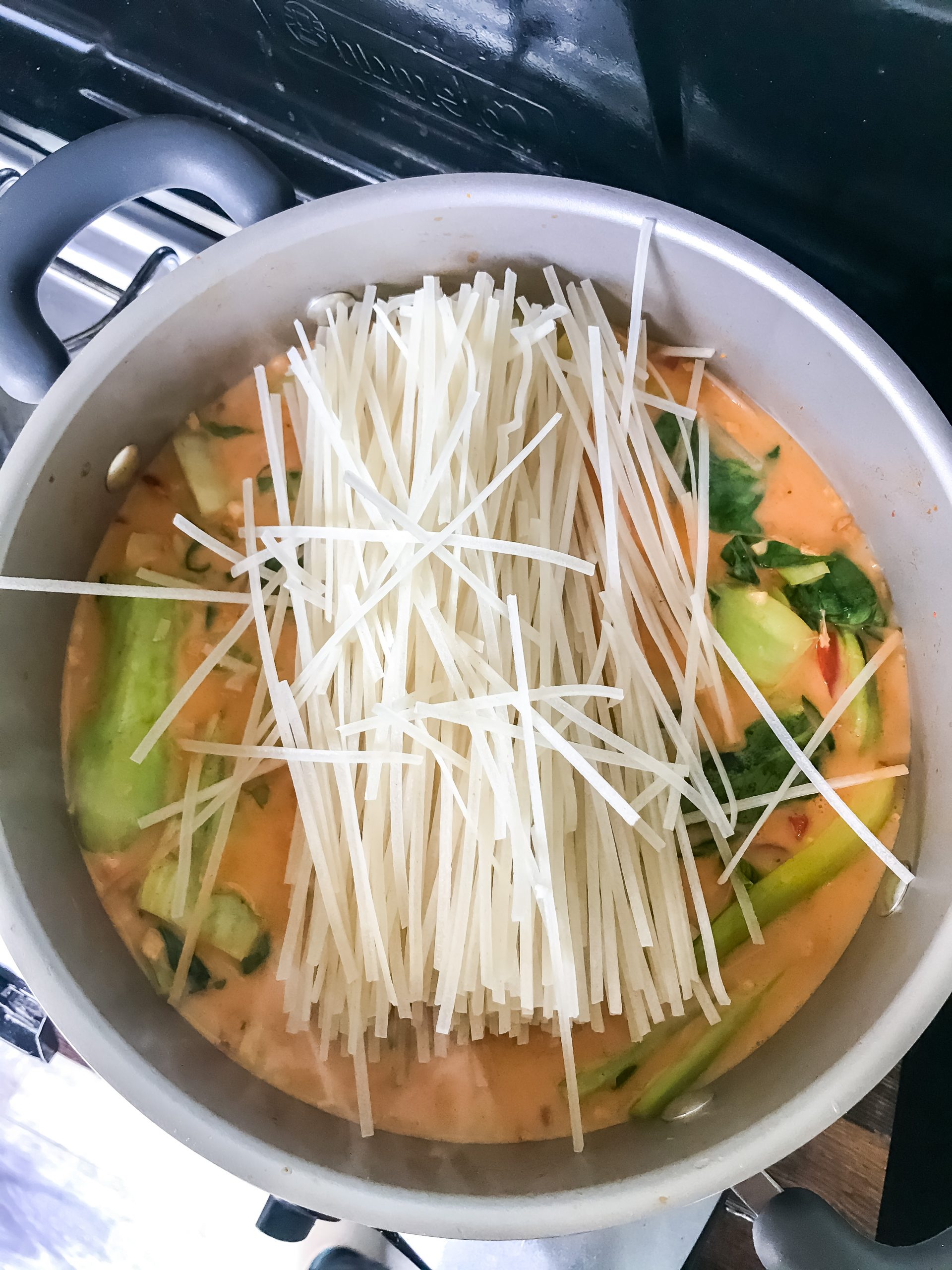 Rice noodles freshly added to the almost-finished coconut curry soup.