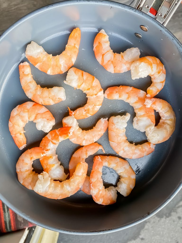 Overhead view of seared shrimp in a frying pan.