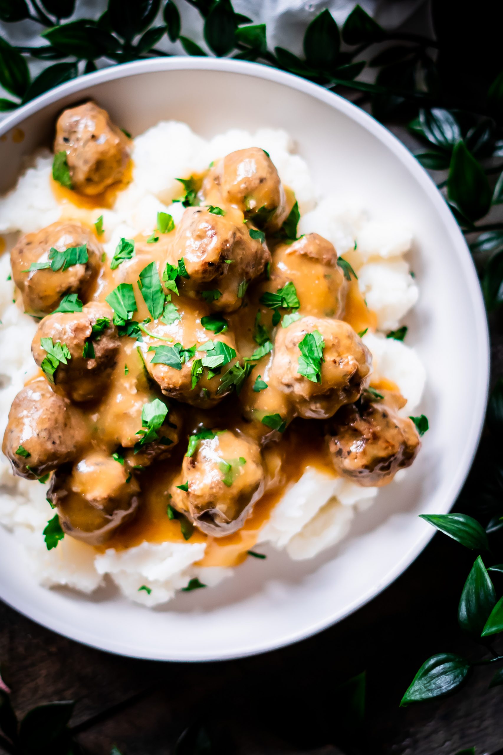 Overhead view of dairy free swedish meatballs smothered in gravy on mashed potatoes