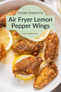 Overhead view of Air Fryer Lemon Pepper Wings ready for serving with glaze and fresh zest and lemon slices.