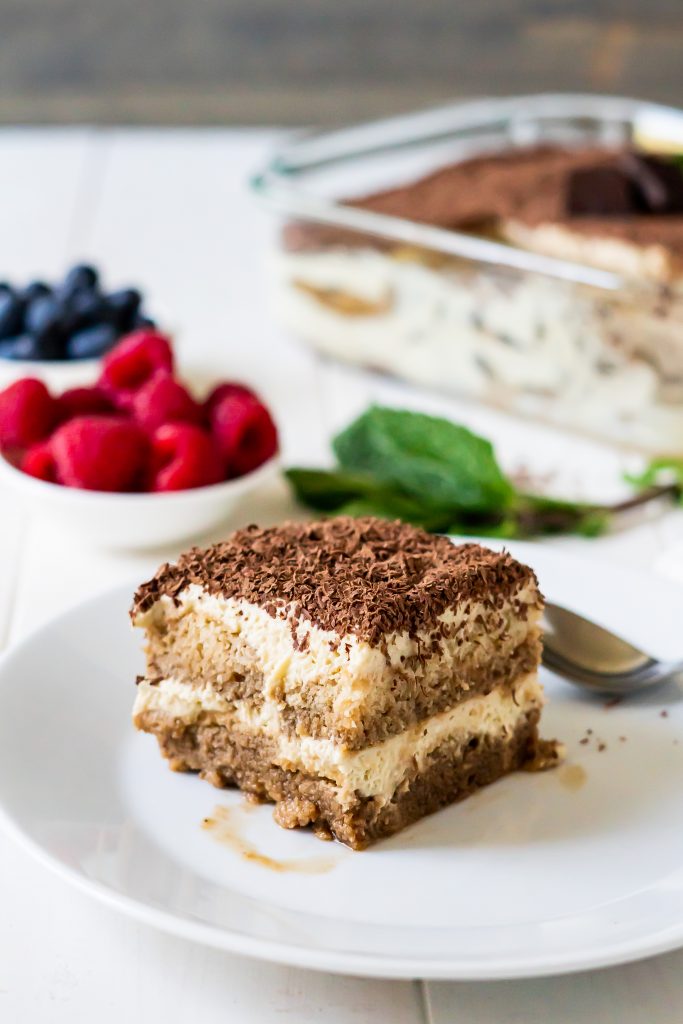 Final dairy free tiramisu slice served with berries and mint leaves for optional garnish.