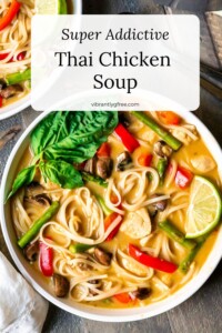 Overhead view of a large bowl of Thai Chicken Soup with rice noodles and veggies. Text Overlay: Super Addictive Thai Chicken Soup.
