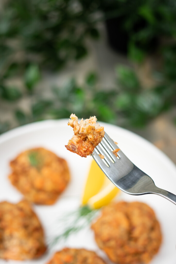 Side view of a tasty bite of baked salmon cake on a fork.