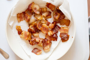 Overhead view of bacon pieces freshly crisped on a paper towel lined plate.