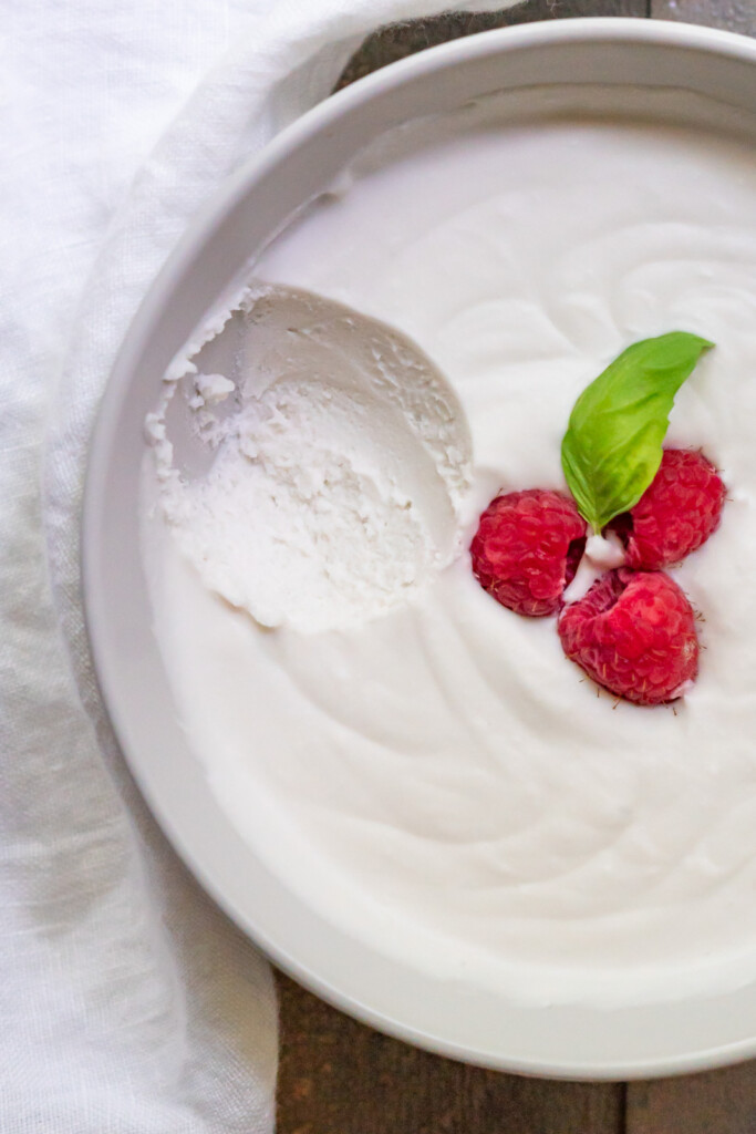 Overhead up close view of this dairy free whipped cream recipe topped with raspberries and a fresh mint leaf.