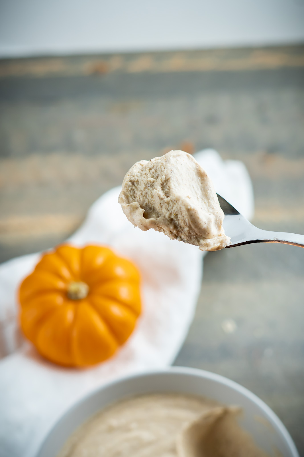 A close up shot of a big spoonful of creamy pumpkin spice whipped cream. 