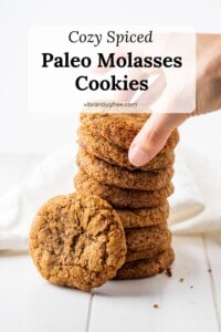 A side view of a stack of paleo ginger molasses cookies with one laying in the front to show the crackly top and chewy texture!