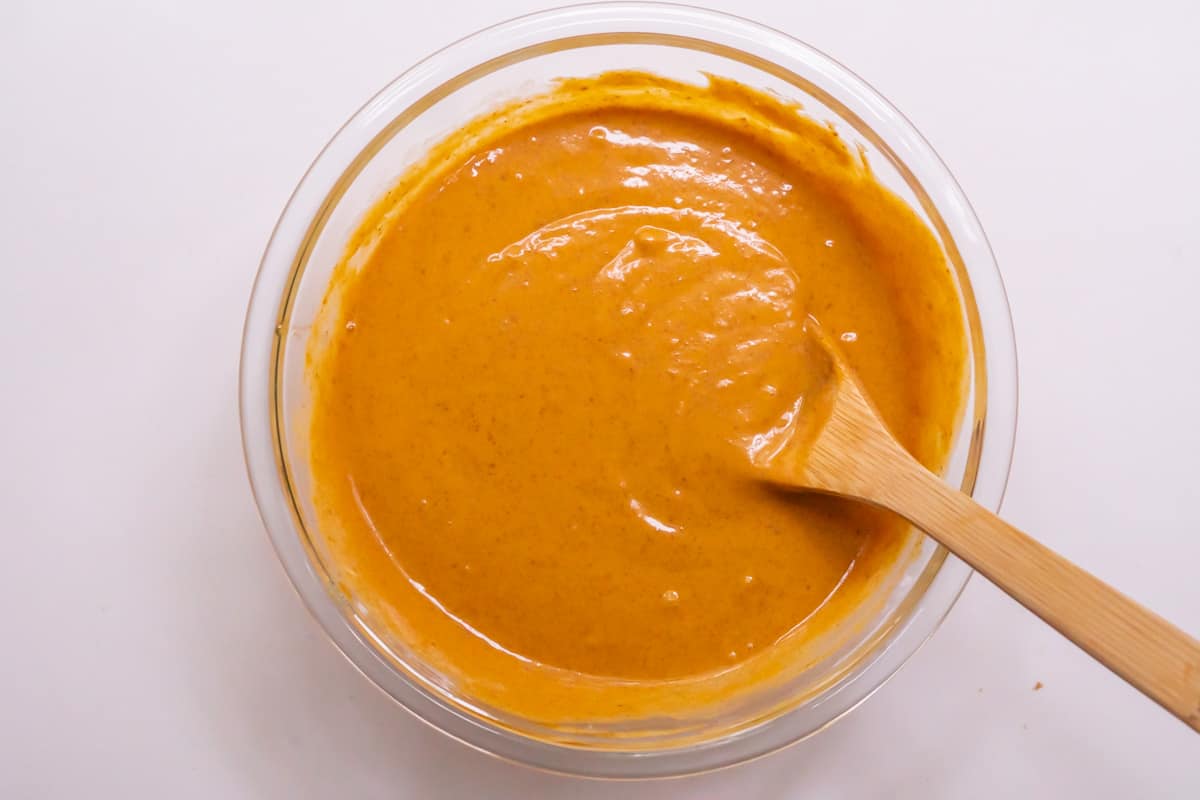 A large mixing bowl filled with pumpkin pancake batter with a smoothie-like consistency.