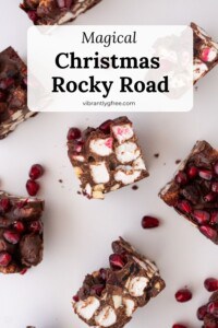 Several pieces of Christmas Rocky Road arranged on a white background to show the top and sides of the candy pieces.