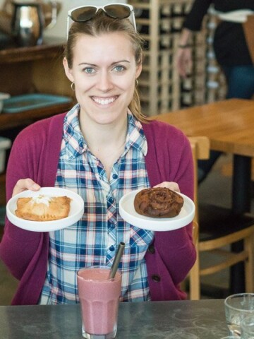 Jamie with two gluten free and celiac friendly baked treats in a bakery.