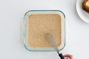 A glass baking dish with coconut milk and egg mixture for making french toast.
