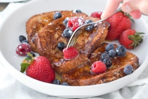A fork cutting into a stack of dairy-free french toast.