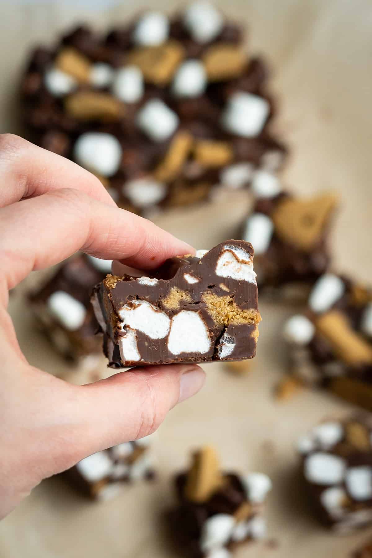 A hand holding a piece of tasty S'mores Rocky Road!