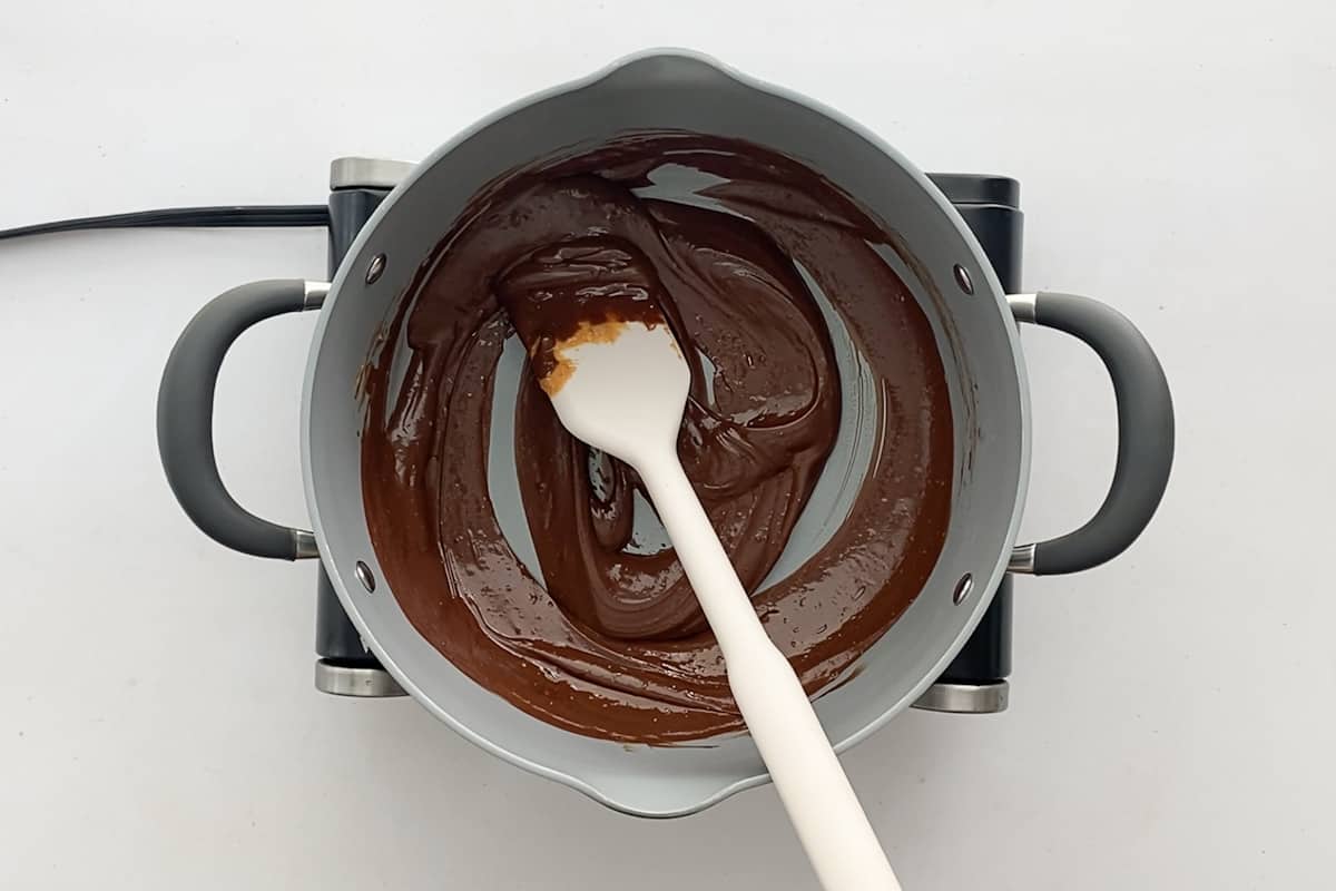 Overhead view of a medium pot with melted chocolate mixture.