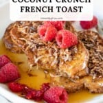 Three slices of coconut crunch french toast served on a plate with fresh raspberries and maple syrup. A bite is removed to show the amazing souffle texture!