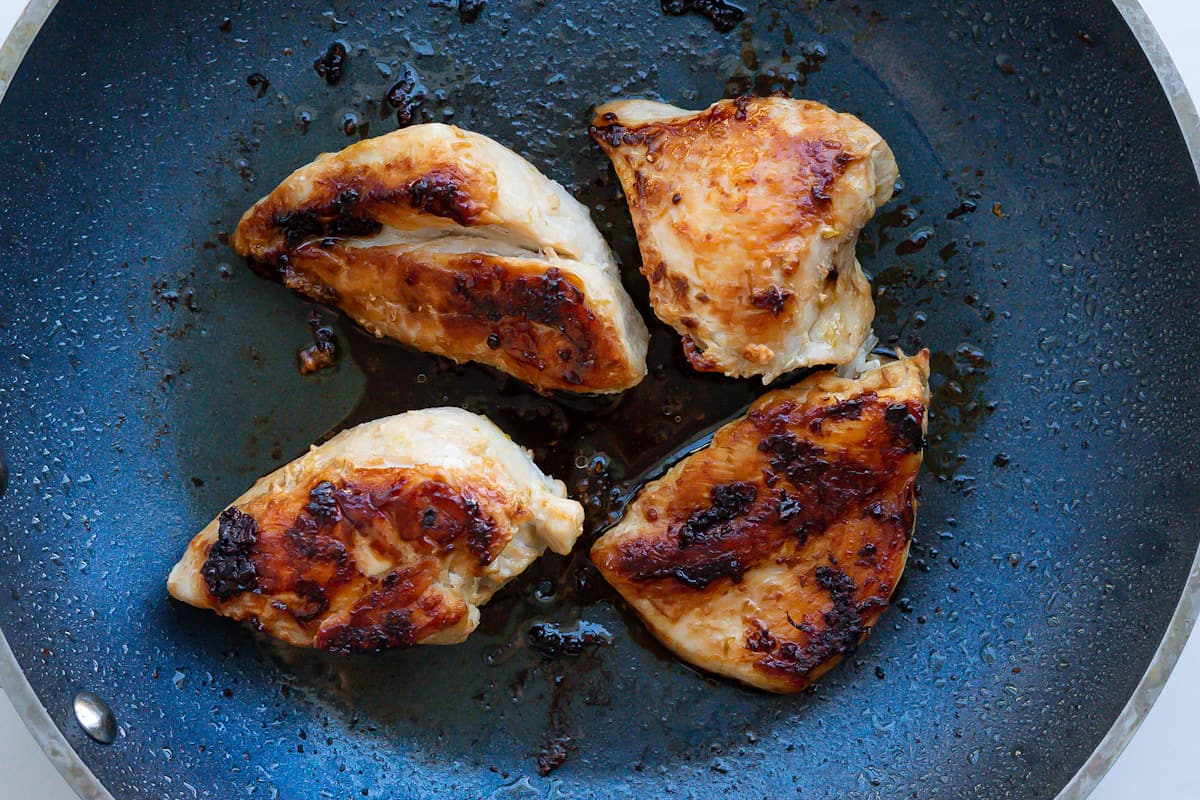 A skillet with pan fried chicken breasts with a nice flavorful crust.