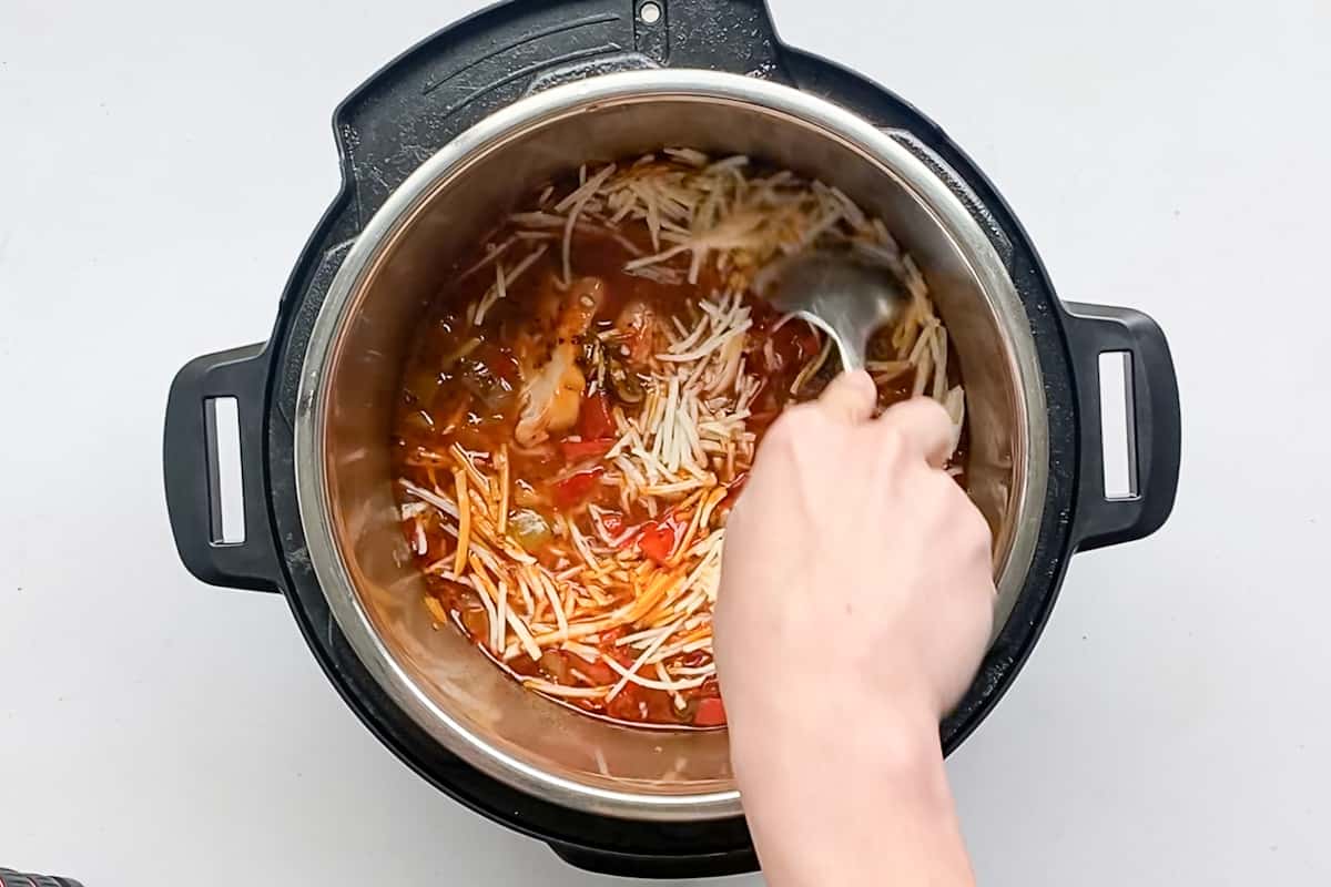 Stirring cheese into the instant pot chicken cacciatore recipe.