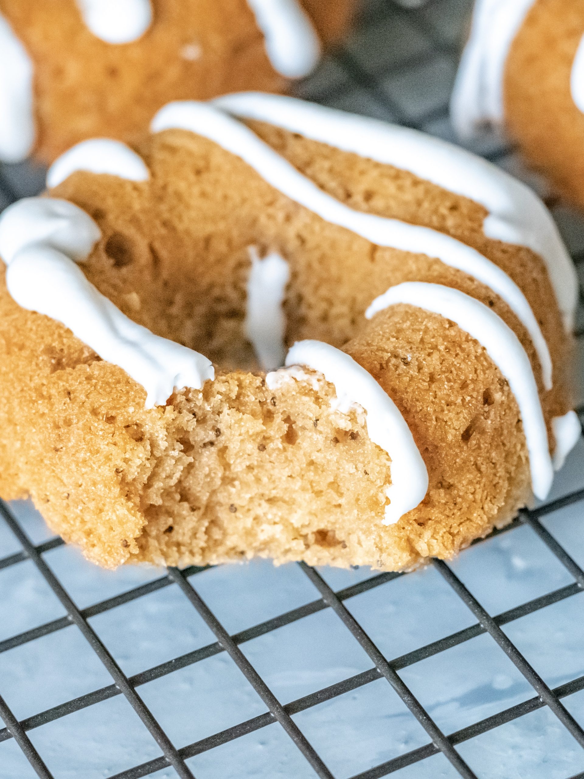 A gluten-free pumpkin donut drizzled with coconut whipped cream icing.