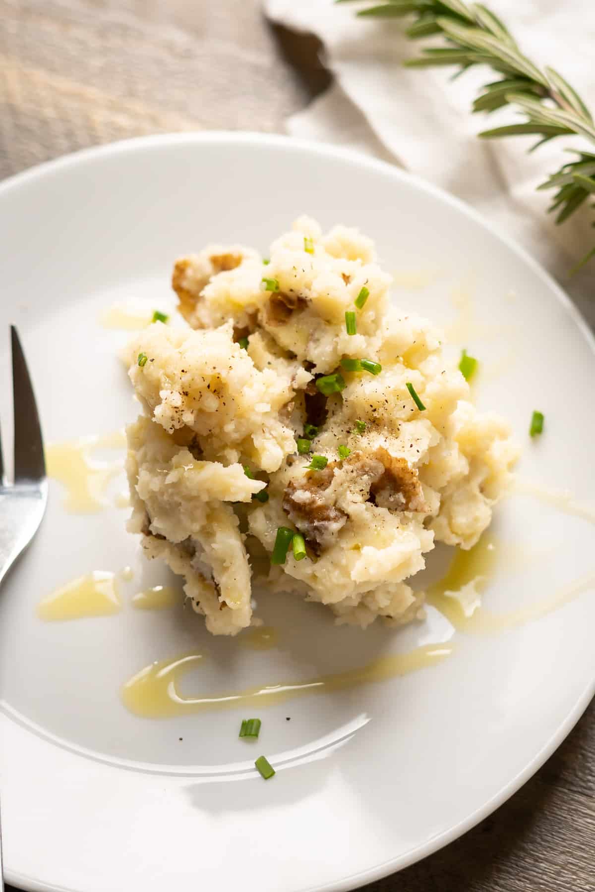 A serving of dairy-free mashed potatoes garnished with green onions on a plate ready to serve.