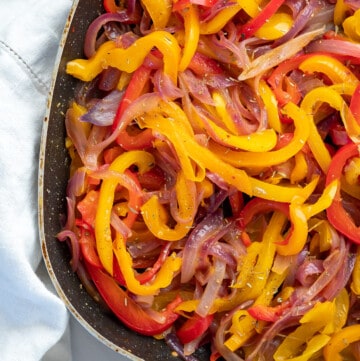 A skillet of caramelised sauteed peppers and onions ready to serve.