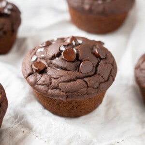 Gluten free double chocolate muffins arranged on a white tablecloth.