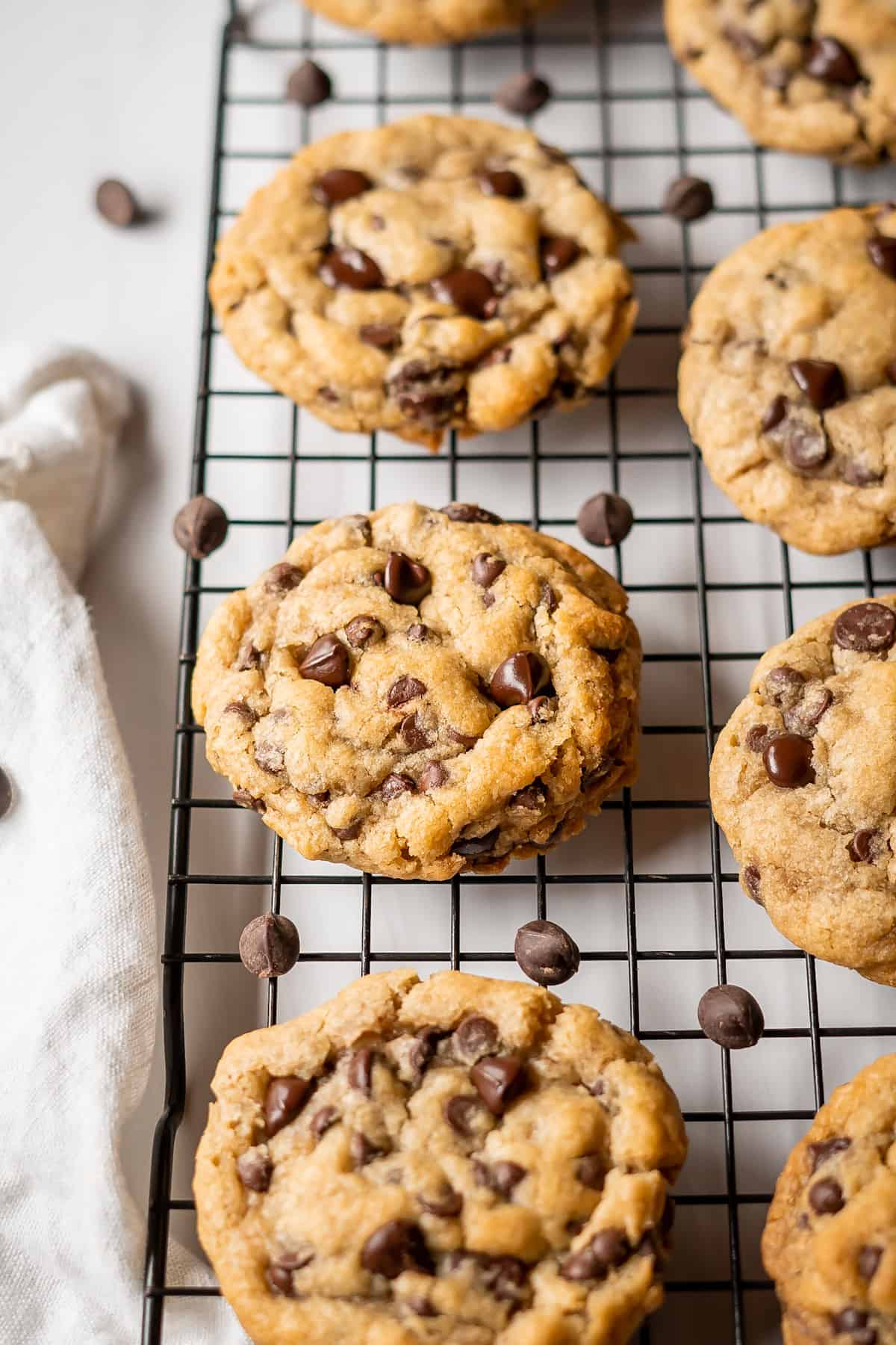 A cooling rack full of freshly baked vegan and gluten-free chocolate chip cookies.
