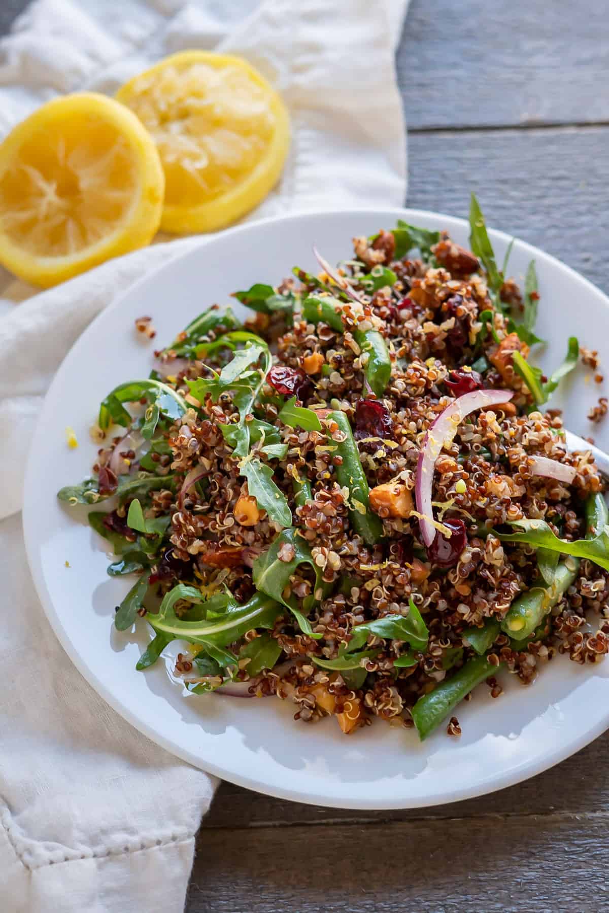 A large lunch serving of arugula quinoa salad on a plate.
