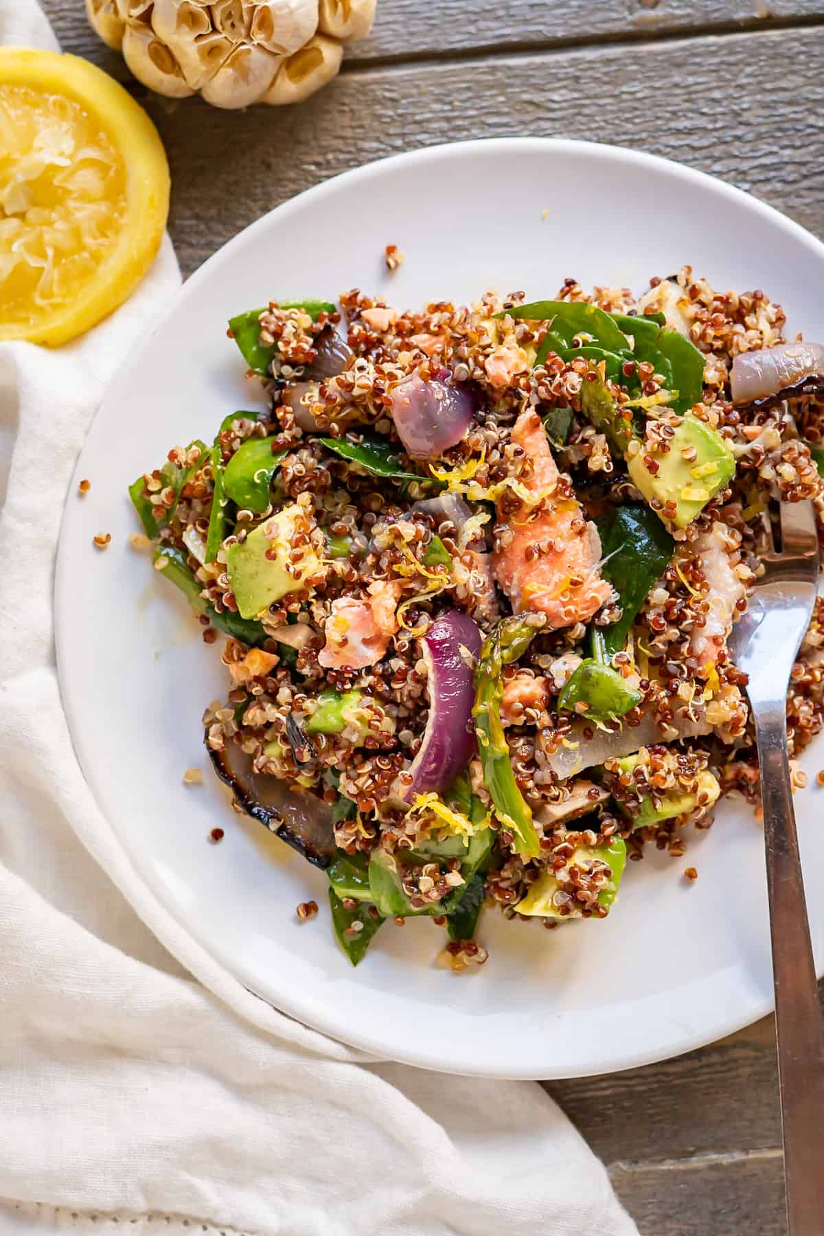 A large meal-sized serving of salmon quinoa bowl on a plate.