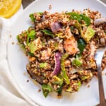 A large meal-sized serving of salmon quinoa salad on a plate.