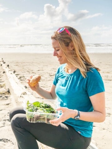 A women enjoying gluten free food on the beach.