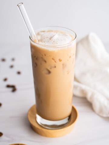 A tall glass of iced brown sugar shaken espresso with whipped cream.