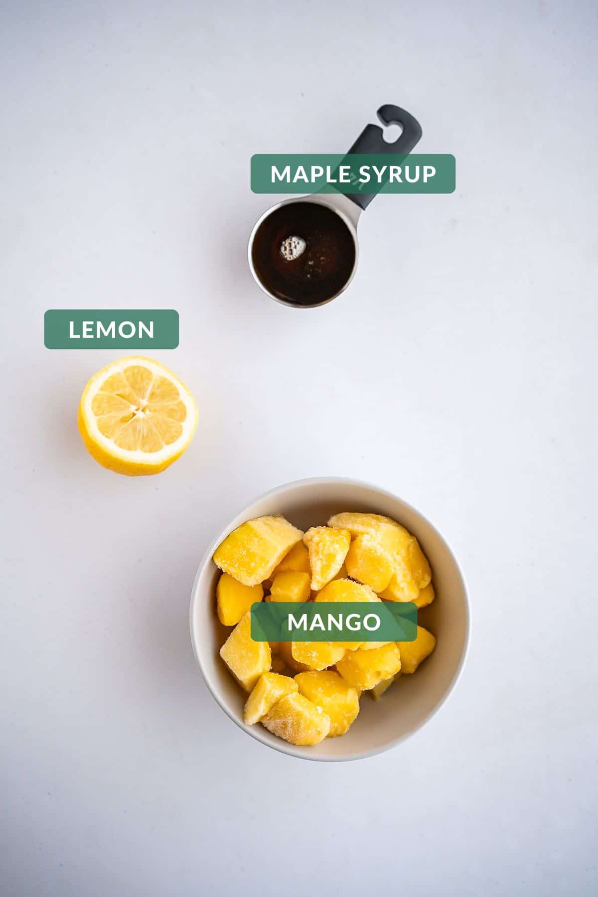 The 3 ingredients you need to make healthy mango popsicles: maple syrup, lemon, and mango.