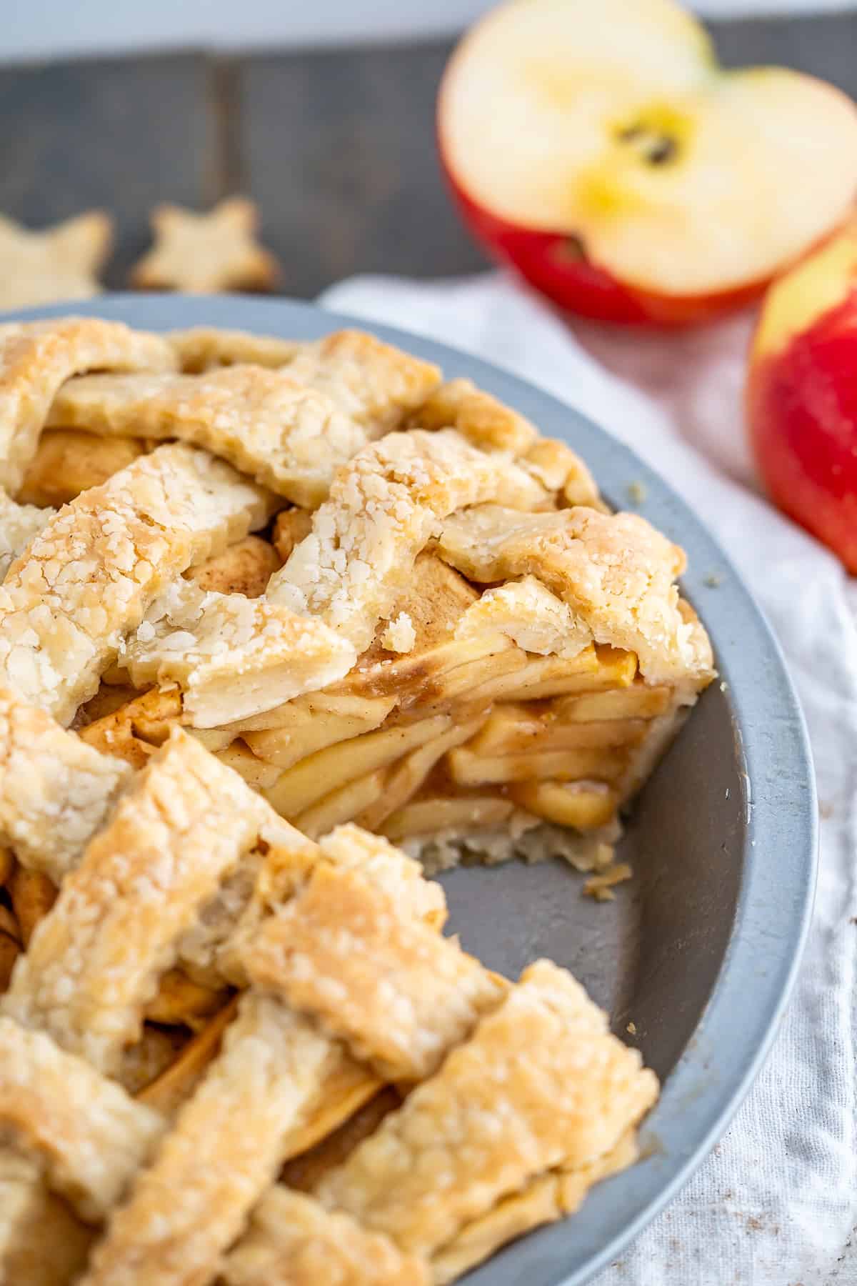 Side view of a gluten-free apple pie to show the layers of apple filling and lattice top crust.