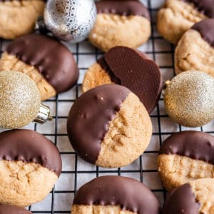 A close up of a gluten-free peanut butter cookie dipped in chocolate to show the cookie and chocolate textures.