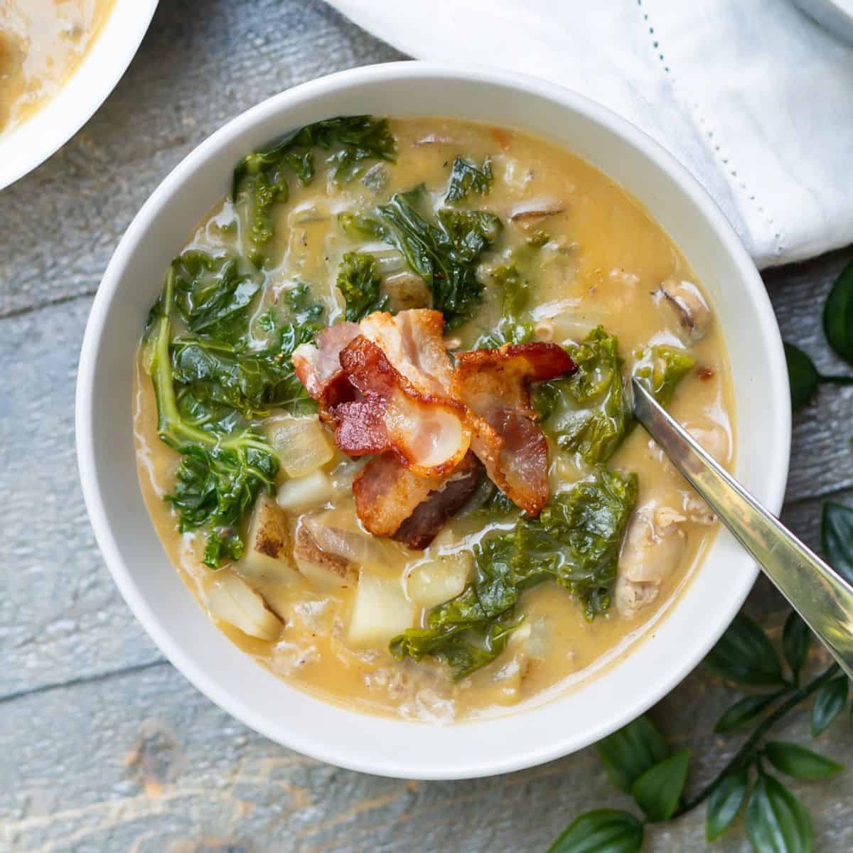 Final Healthy Zuppa Toscana soup served in a bowl with bacon pieces sprinkled on top.