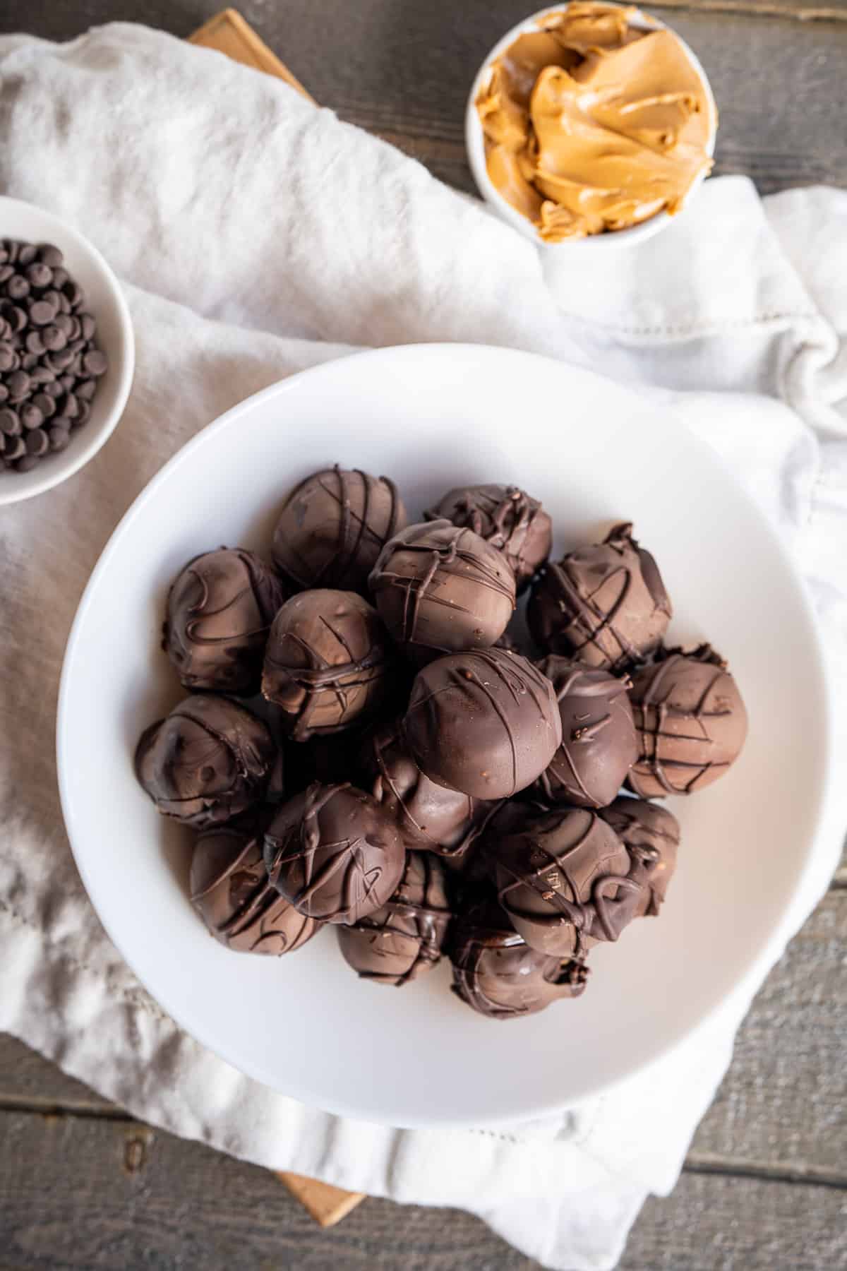 A pile of no bake peanut butter balls covered in chocolate.