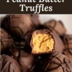 A pile of chocolate covered peanut butter balls with one split open to show the creamy peanut butter center.