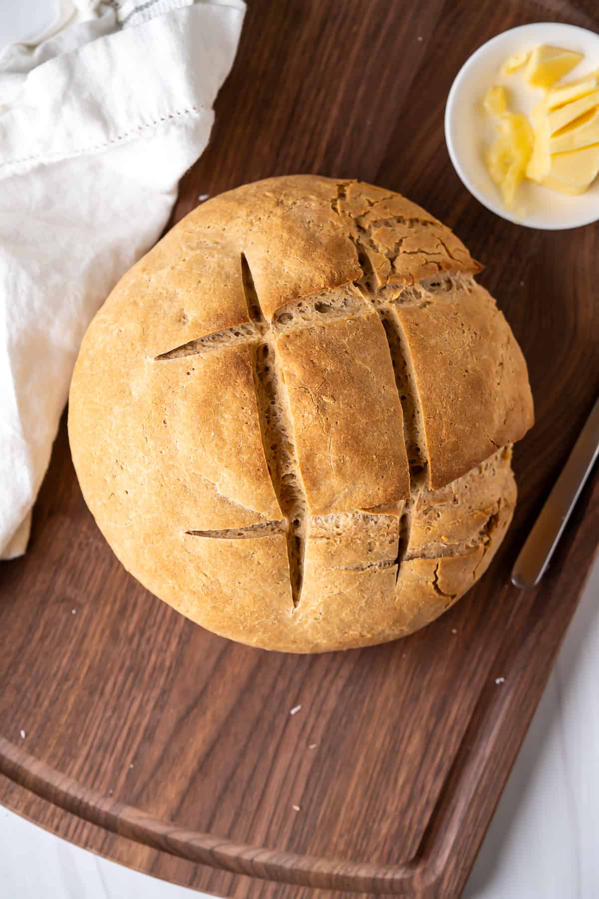 The final baked gluten-free artisan bread loaf on a cutting board.