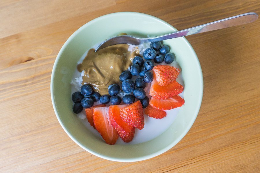 An easy rice porridge with blueberries, strawberries, and sunflower seed butter.