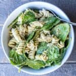 A serving bowl of Creamy Avocado Pasta with chicken and black pepper.