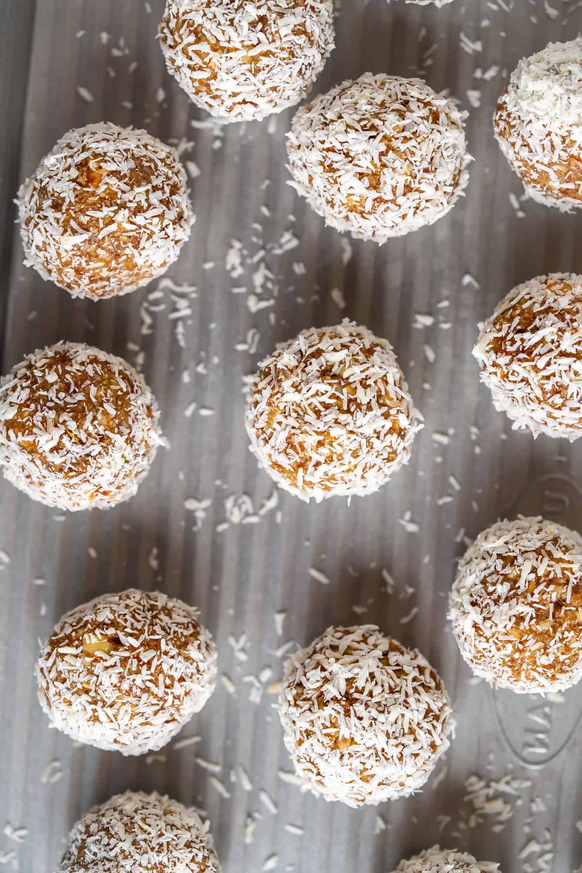 A tray of freshly made date nut balls rolled in shredded coconut.