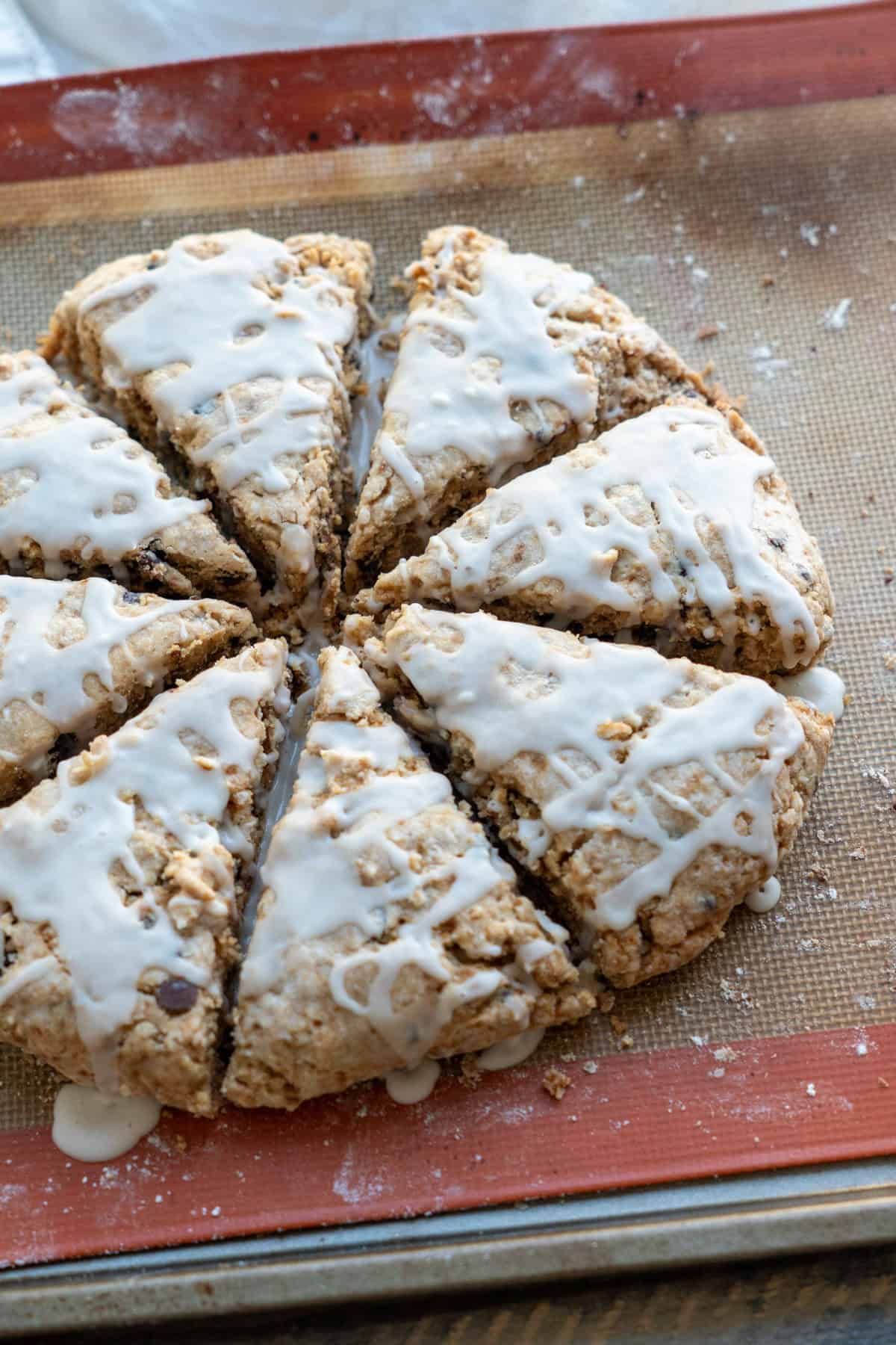 A side view of a tray of freshly baked and glazed gluten-free scones.