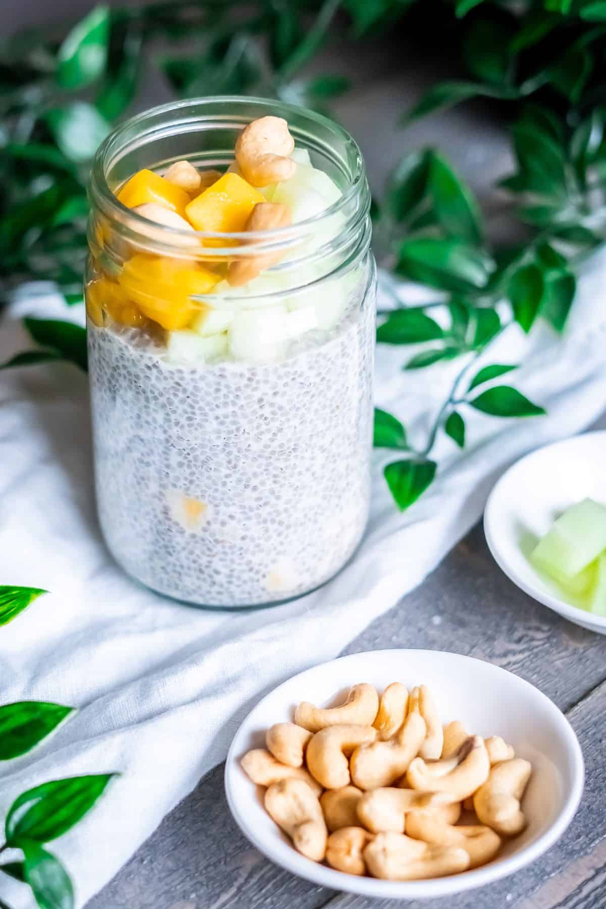 Mango coconut chia pudding with several topping options to choose from in dishes.