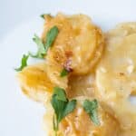 A serving of dairy-free scalloped potatoes with a rich golden sauce.