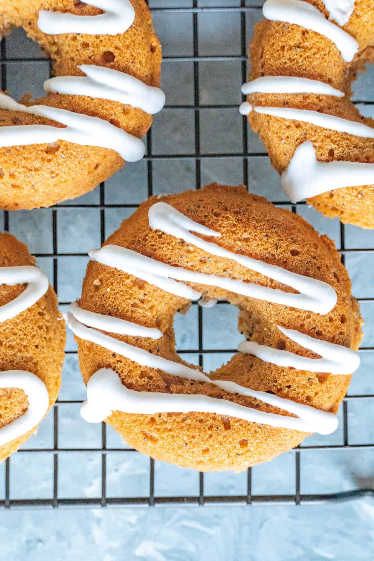 Paleo pumpkin donuts topped with maple syrup sweetened coconut cream.