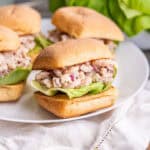A side view of four loaded shrimp salad sandwiches on ciabatta.