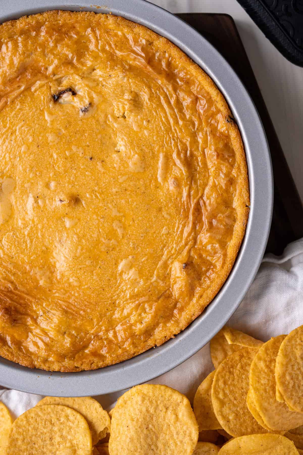 A close up of the bubbly cheesy top crust on a dairy-free buffalo chicken dip.
