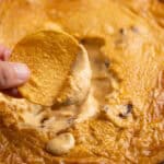 A chip dipped into creamy buffalo chicken dip.