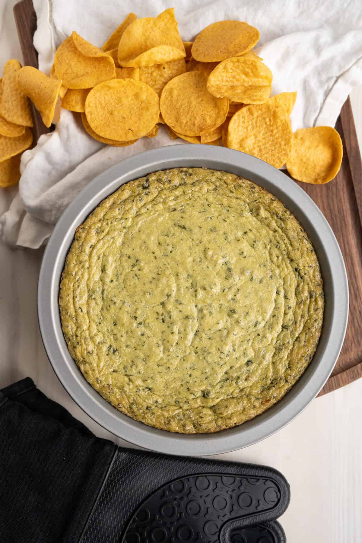 Dairy-Free Spinach Artichoke dip surrounded by tortilla chips.